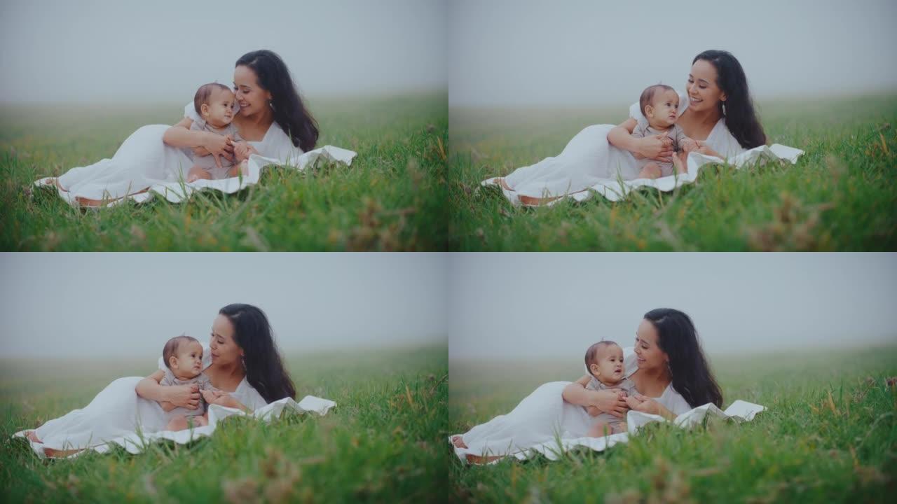 母亲和年幼的婴儿草丛草地小草亲情陪伴