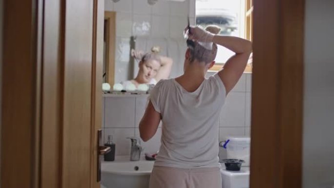 女人在浴室的镜子前染头发
