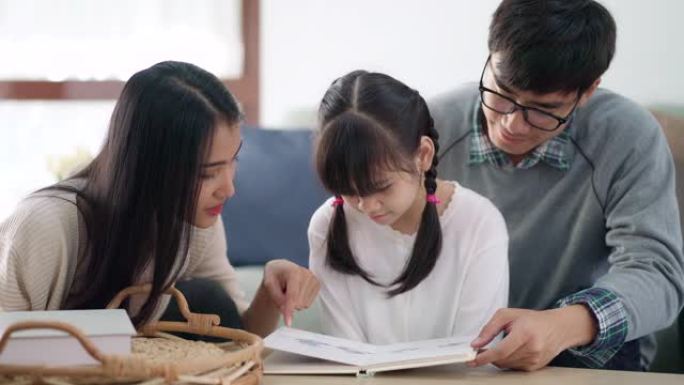 4K UHD掌上电脑: 亚洲女孩与家人一起在客厅阅读童话故事书，同时封城冠状病毒新型冠状病毒肺炎大流