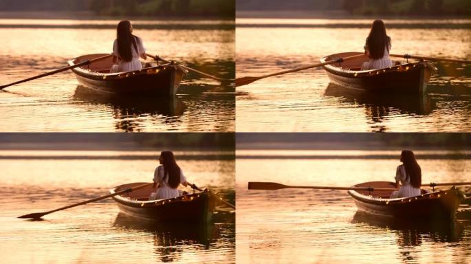 日落时分，一艘装饰好的小船上的慢动作年轻女子划过湖面