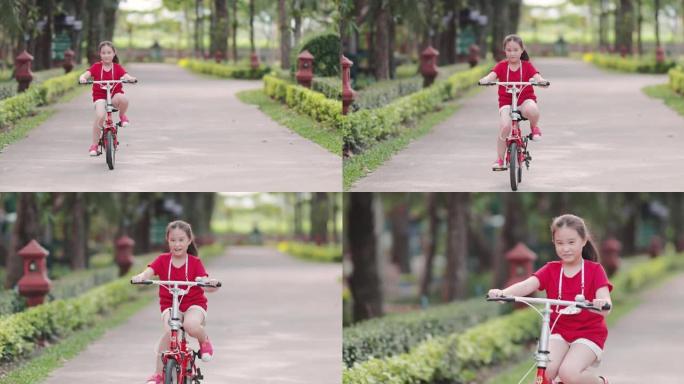 快乐亚洲女孩骑自行车在公园