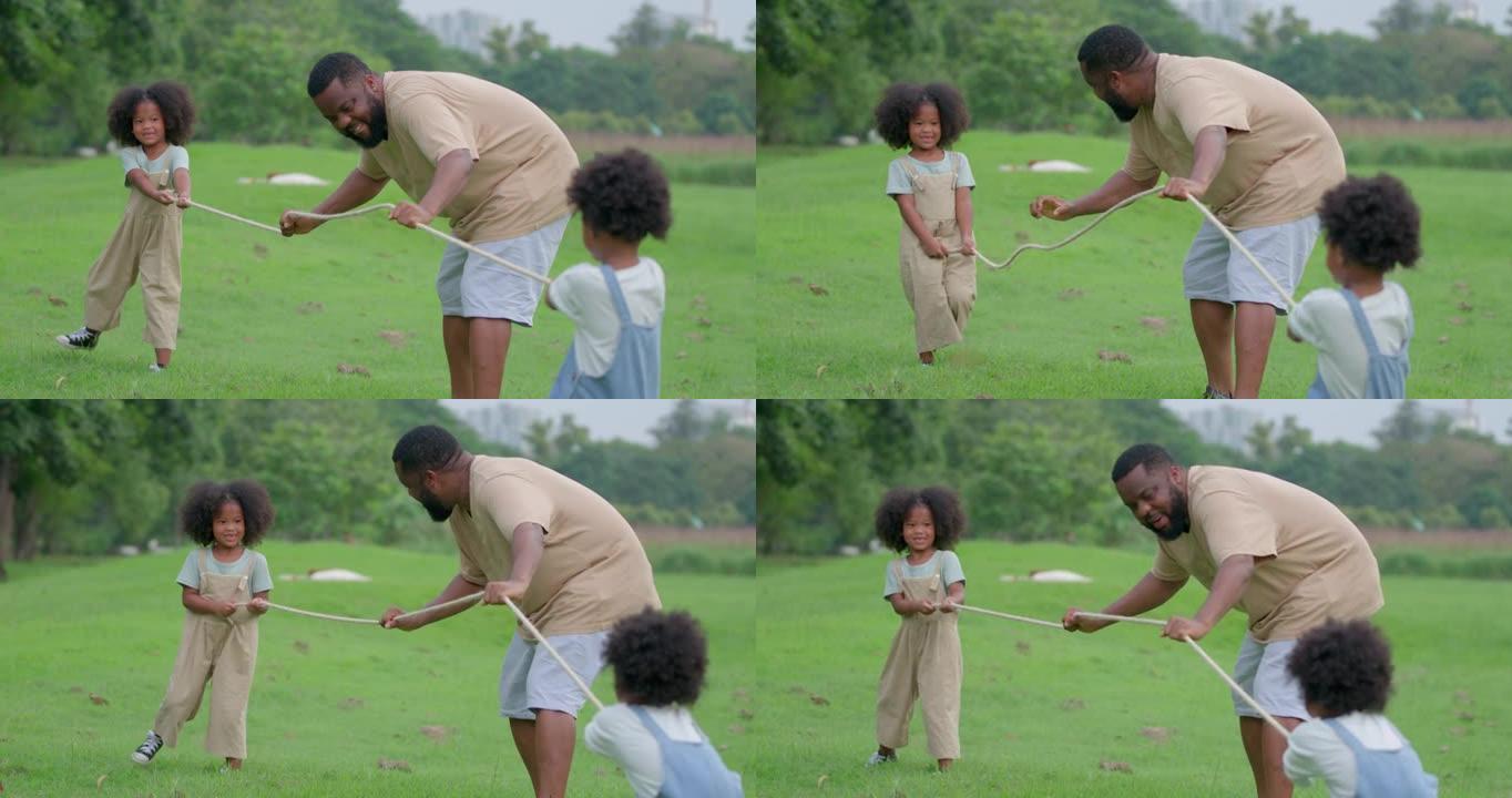 一个黑人女儿的父亲和儿子正在公园里玩拖船。在快乐的锻炼和共度时光中，每个人的脸都容颜。