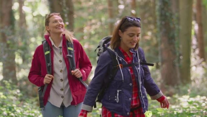 两个女性朋友在假期中徒步穿越树林，享受大自然的乐趣-慢动作拍摄