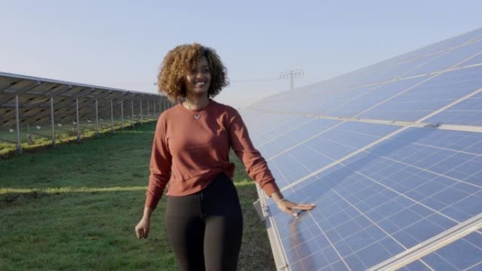 在太阳能电池板农场散步的非洲快乐妇女