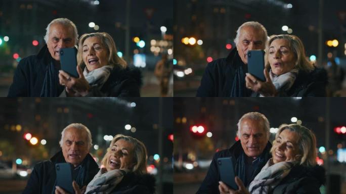 晚上，一对幸福的高级夫妇正在市中心用智能手机进行自拍或视频通话。