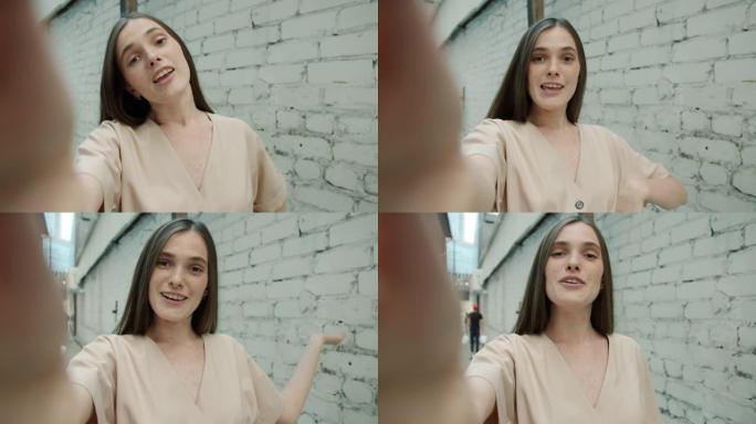 可爱的年轻女士的肖像，雀斑在户外视频通话时聊天和挥手