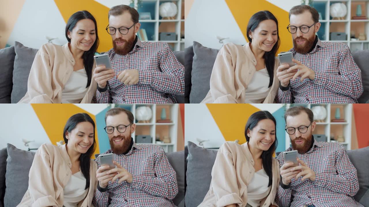 男人和女人使用智能手机看着屏幕，笑着享受内容