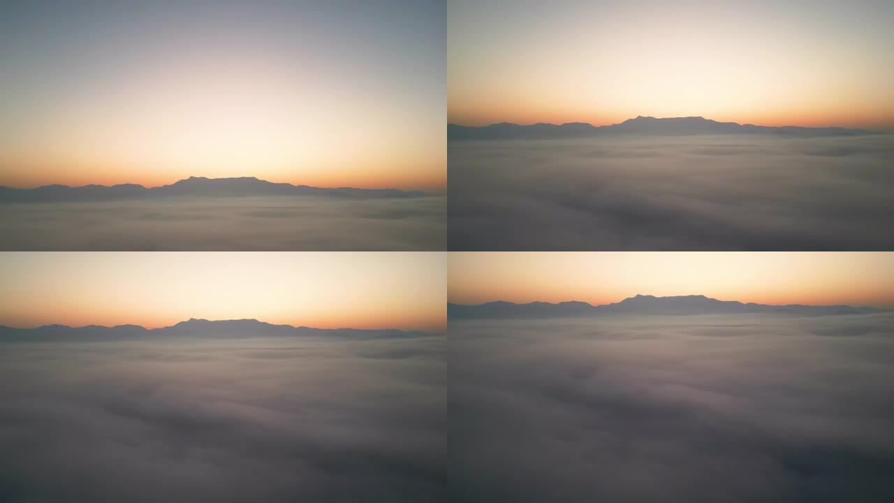 空中拍摄云层之上，并在日出的山上移动薄雾