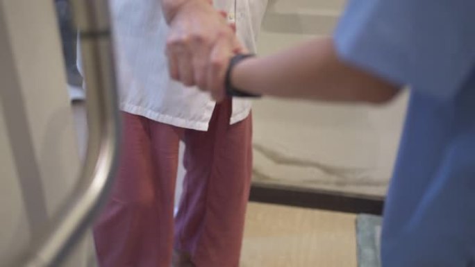 女护士协助老年病人在卫生间或卫生间行走