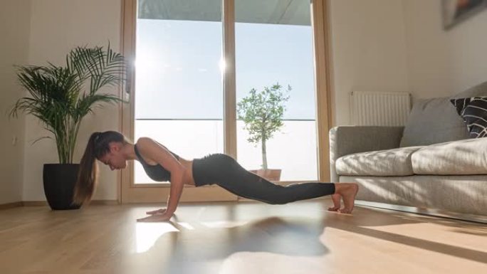 运动活跃的女人在客厅在家练习瑜伽
