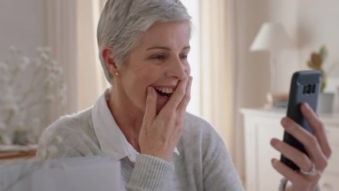 美丽的成熟女人使用智能手机进行视频聊天祖母享受对话看起来惊讶地分享生活方式在手机上聊天在家放松4k