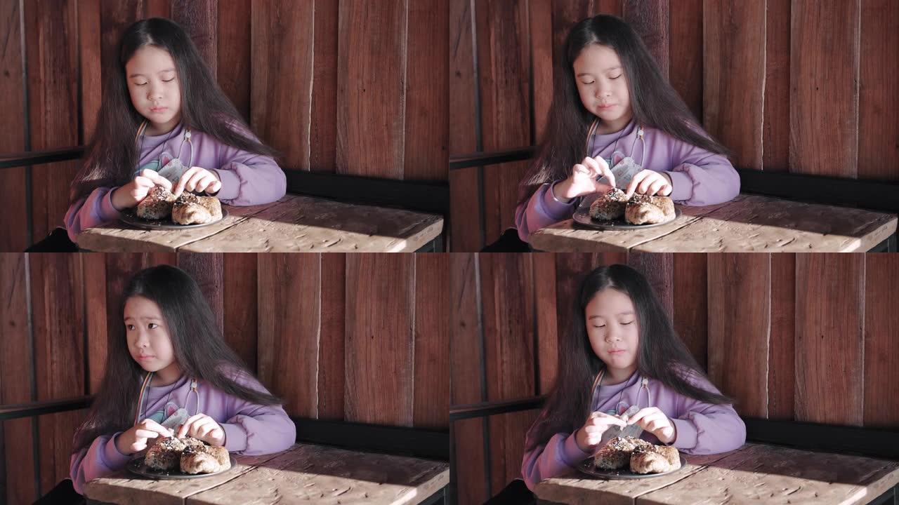 早餐吃羊角面包的亚洲女孩