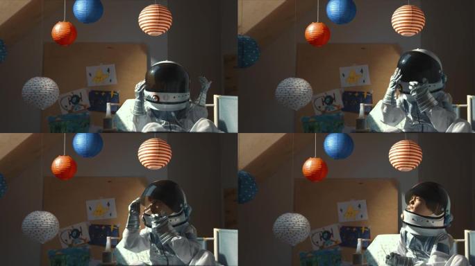 太空旅行梦想。小男孩在太空主题房间的床上醒来，打开头盔遮阳板看太阳光。