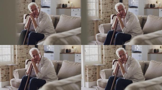 4k视频片段，一名老人坐在家里，手杖是木制的拐杖