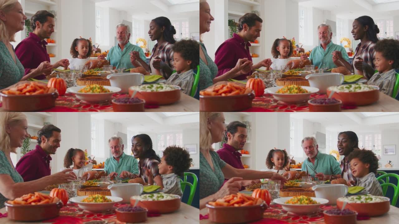 多代家庭在家庆祝感恩节，一起吃饭前祈祷
