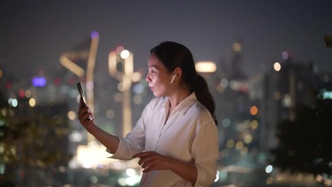 亚洲女商人在城市的手机上进行视频通话