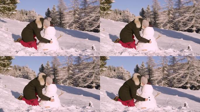 特写: 开朗的年轻女子在阳光明媚的冬日堆雪人。