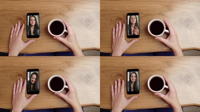 POV人在喝咖啡时通过智能手机与一名年轻女子进行视频通话
