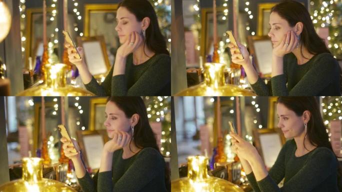 一个美丽的女人坐在梳妆台上并在电话上发短信的视频剪辑