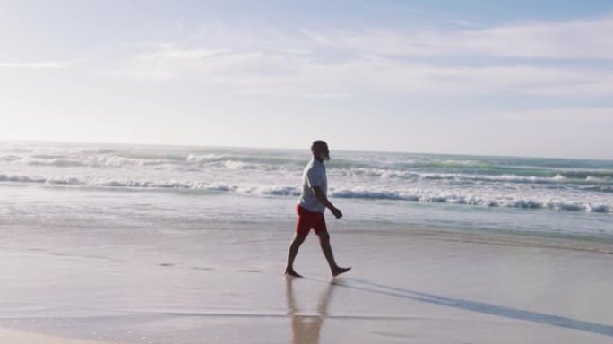 资深非洲裔男子在海滩散步