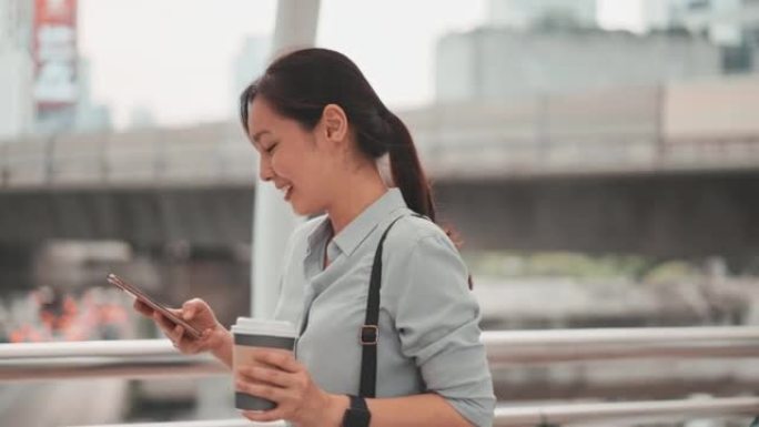 亚洲女子在城市中行走并使用智能手机