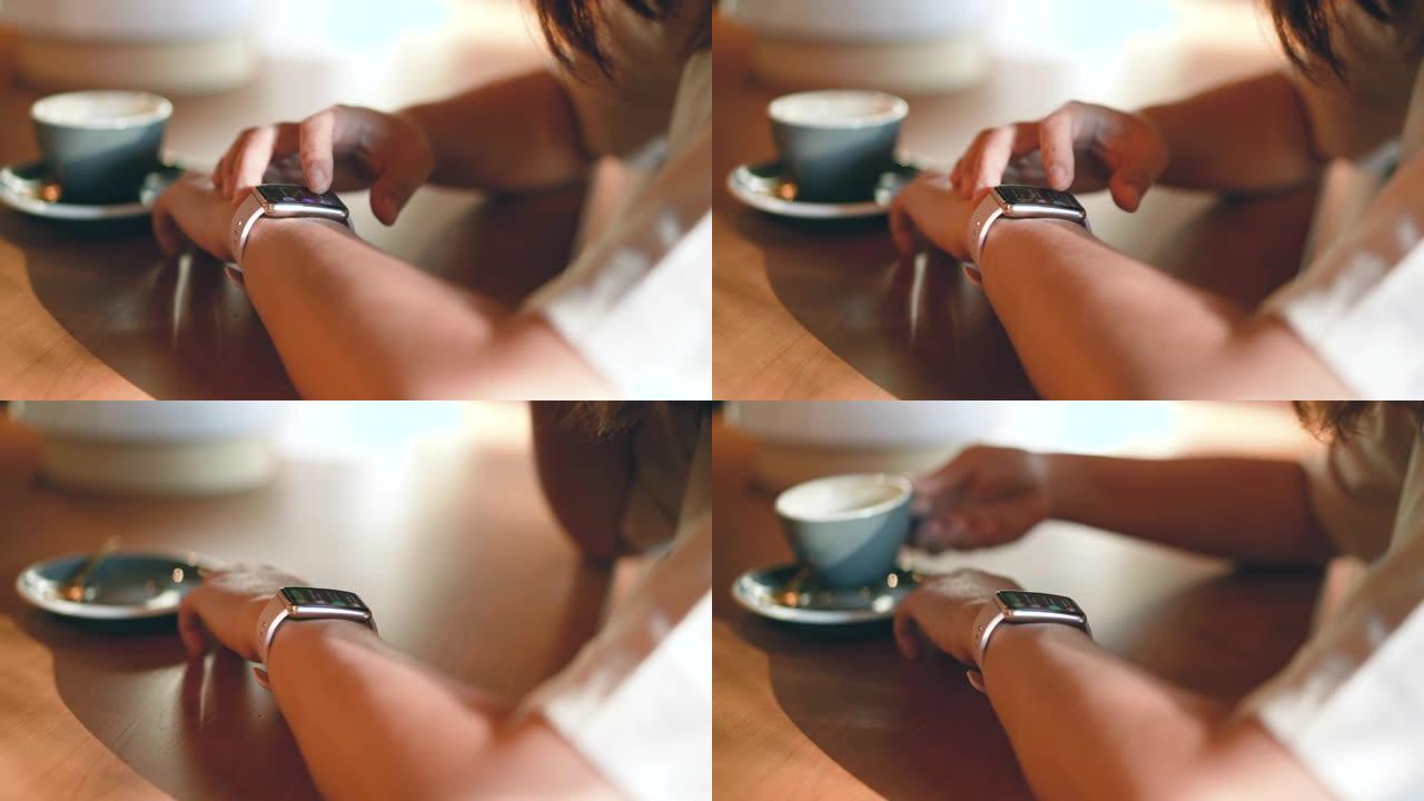 女人在咖啡馆喝咖啡放松，触摸智能手表