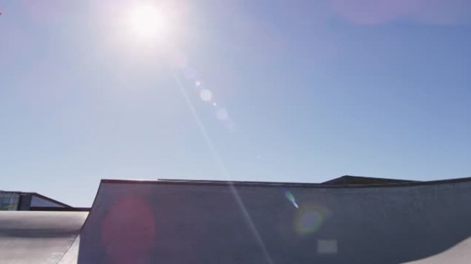 在阳光明媚的日子里，高加索人骑在滑板上跳跃