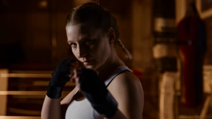 慢动作动机的女拳击手在镜头前摆出战斗姿势
