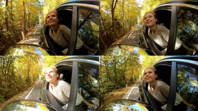 女人在穿越秋天的森林时从车窗外倾斜
