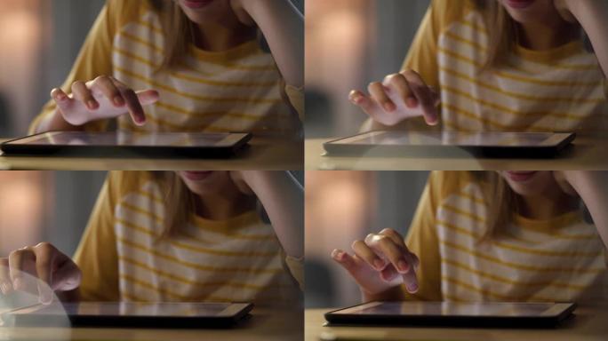 4k视频片段，一个无法识别的女孩独自坐在家里并使用数字平板电脑
