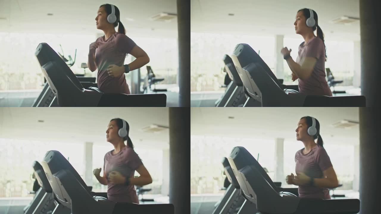 亚洲运动女子在健身房的跑步机上锻炼