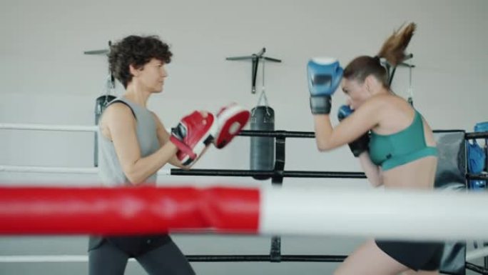 在健身房训练的年轻女性的慢动作享受拳击练习
