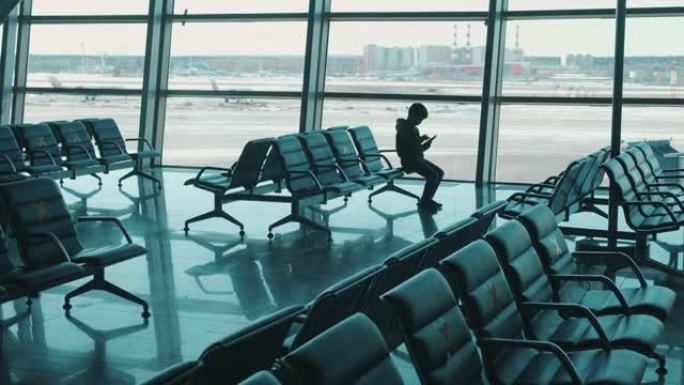 空荡荡的机场大厅，一个有标记的座位上有一个男孩