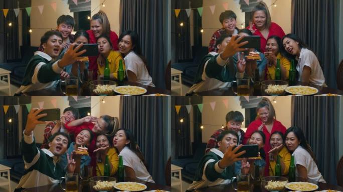 一群年轻的亚洲朋友与生日蛋糕看相机拍摄视频照片在移动应用程序有趣的视频聚会在夜生活室内家庭。
