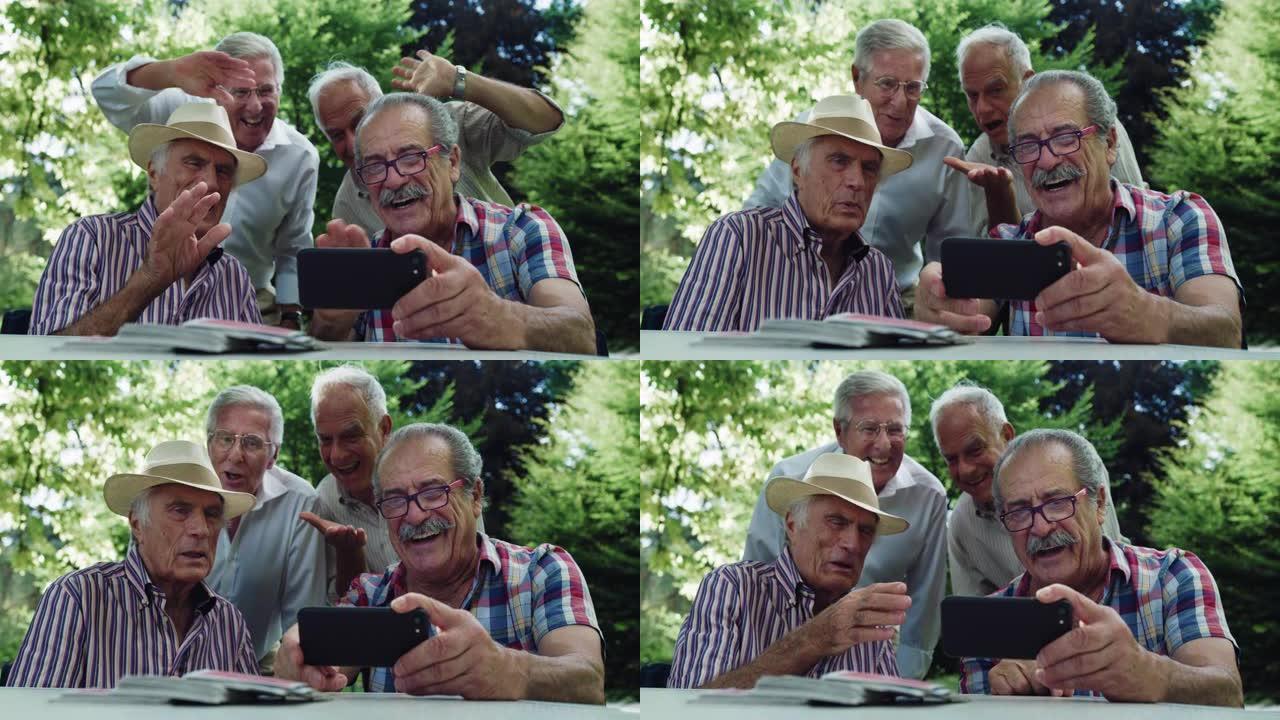 一群老人坐在公园里用智能手机与朋友进行视频通话。由于互联网和技术，老年朋友保持联系。银色冲浪者的概念