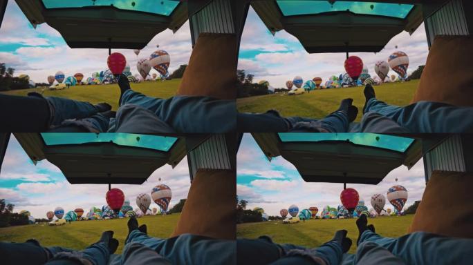 POV夫妇躺在货车上，看着农村地区的热气球
