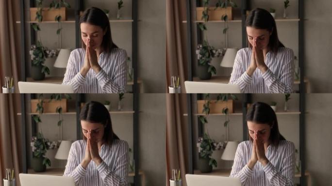 宗教妇女坐在书桌前合掌向上帝祈祷