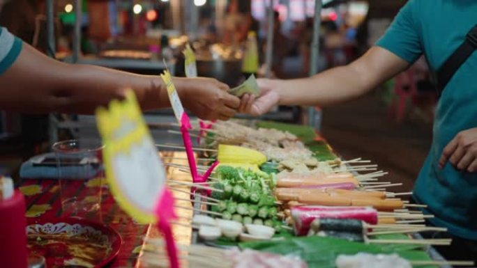 顾客为夜市上的食物付费