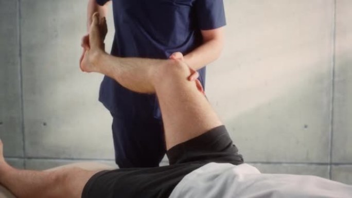 接受物理治疗的年轻男运动员的特写镜头，专业运动按摩师治疗轻度肌肉或关节损伤。肌肉骨骼疼痛治疗和康复概
