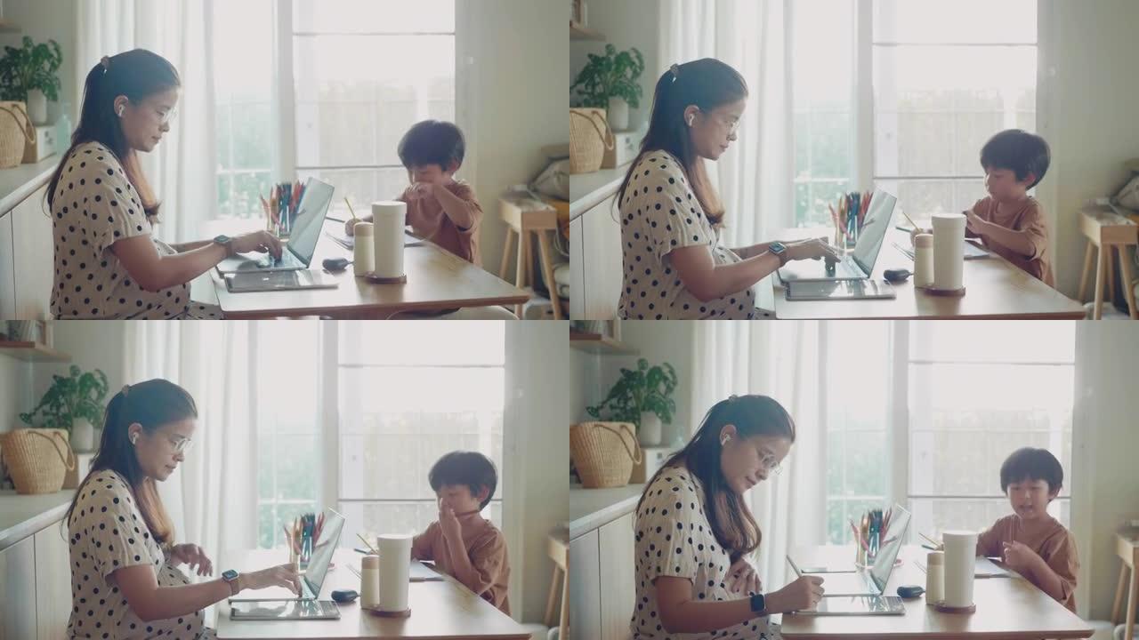 亚洲儿子在家和妈妈一起上在线课。