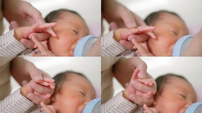 单身母亲牵着他的手给刚出生的男婴喂山羊奶粉。无乳糖配方
