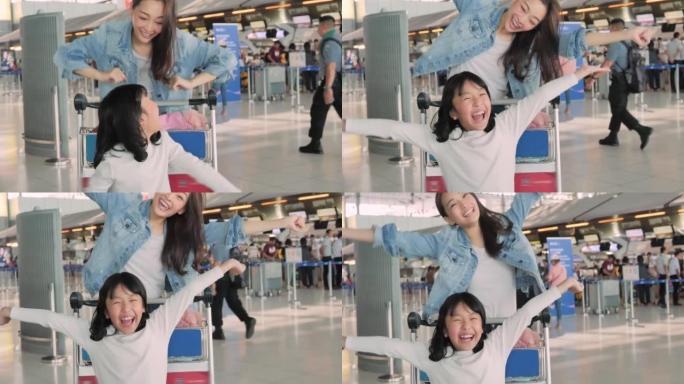 9岁的亚洲年轻妇女和9岁的女童的快乐微笑家庭的兴奋看着相机，伸出双臂准备在机场开始暑假。种族多样化的