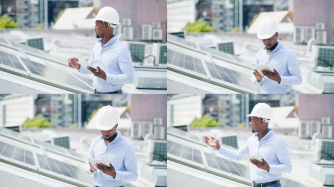 一个年轻人在建筑物的屋顶上安装太阳能电池板时使用数字平板电脑。一名男子在网上从事可再生能源建筑项目