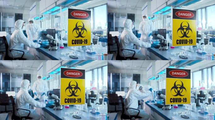 医学研究实验室门上的危险新型冠状病毒肺炎标志: 戴着口罩的科学家团队致力于新型冠状病毒肺炎治疗，疫苗