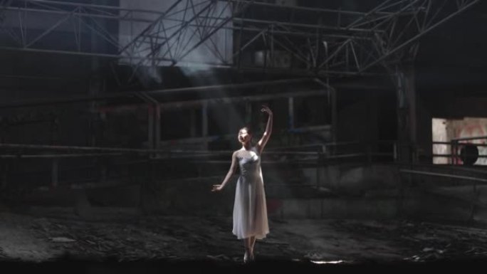 年轻女子美丽的芭蕾舞演员在黑暗的大厅里跳舞