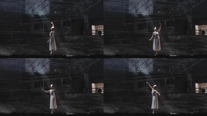 年轻女子美丽的芭蕾舞演员在黑暗的大厅里跳舞
