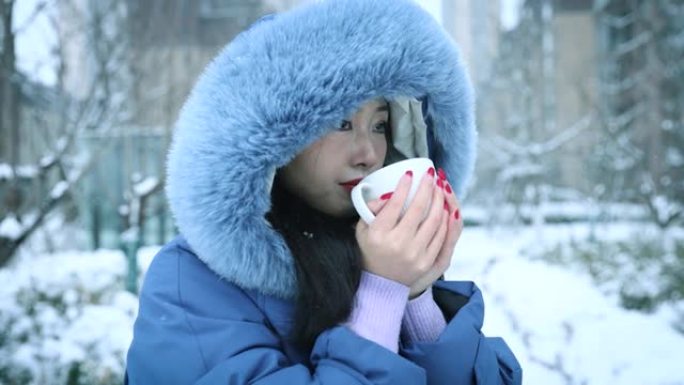 年轻女性在冬天拿着热杯咖啡