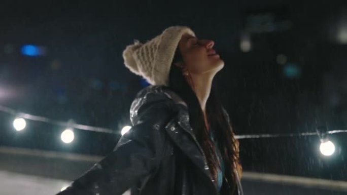 快乐，自由和冬季下雨的女人在晚上，水飞溅，并在葡萄牙的暴风雨中放松。微笑，希望和庆祝黑暗城市天气中有