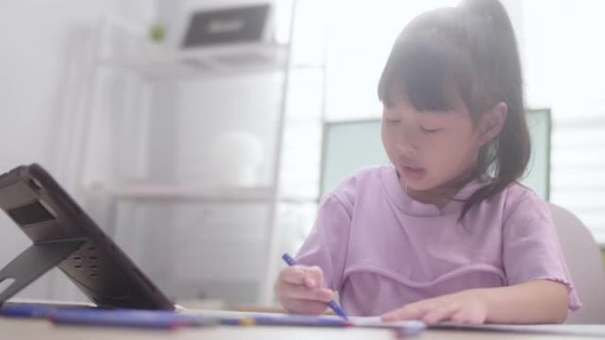 亚洲女儿在家学习数字平板电脑上的在线课程