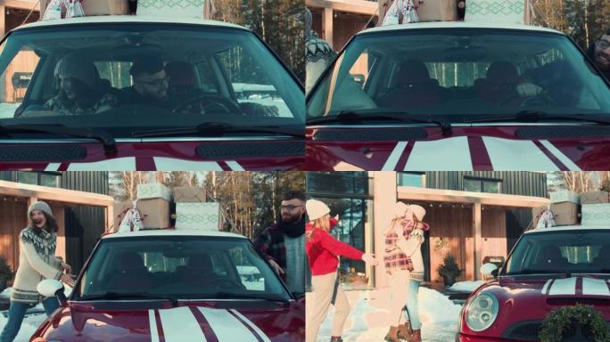 圣诞气氛。年轻快乐的朋友从屋顶上带着礼物的红色车里出来，在雪屋慢动作中拥抱朋友。